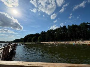 a beach with a pier and a body of water at Domek przy Róży in Ostromice