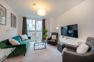 a living room with a couch and a tv at Stylish Apartment by Chelsea-Victoria-Pimlico in London +3 photos