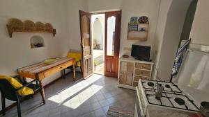 eine Küche mit einem Tisch und einem Herd in einem Zimmer in der Unterkunft Villa Aurora con vista mozzafiato su Strombolicchio in Stromboli