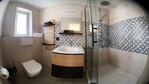 a bathroom with a sink and a shower and a toilet at Sylvie-Steinhardt-Wohnung-4 in List