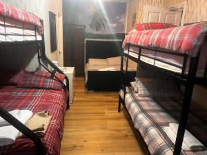 a room with three bunk beds and a couch at BLACKPOOL MERCY Inn HOTEL in Blackpool