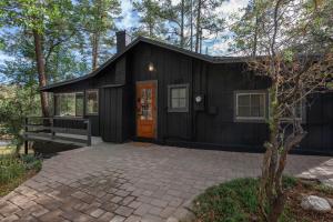 a black house with a bench in front of it at Dancing Pines Cabin in Prescott