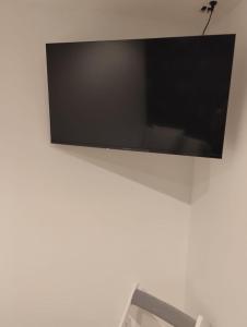 Un televisor de pantalla plana colgado en una pared blanca. en Hostal New Life Madrid, en Madrid