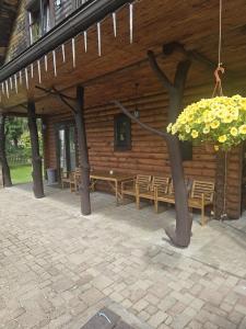 a wooden building with a group of tables and benches at Brīvdienu māja pie Gaujas in Siguļi