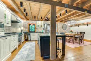 a kitchen with wooden ceilings and a dining room with a table at Peaceful Farmhouse with Fire Pit Near Town and Lake! in Harbor Springs