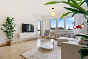 a living room with a couch and a tv at Stylish 2BR Apt in Limpertsberg, Near City Center in Luxembourg