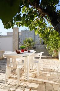 a white table and chairs on a patio at Casetta Dolce Mare - FELICITA' a DUE PASSI dal MARE in Villanova di Ostuni