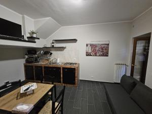 a kitchen and living room with a couch and a table at Vicolo Antico in Vico nel Lazio