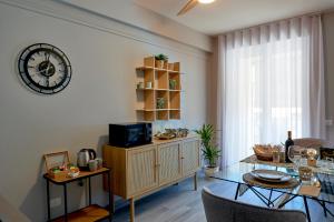 a living room with a table and a clock on the wall at La Marina Apartment Suites in Falerna Marina