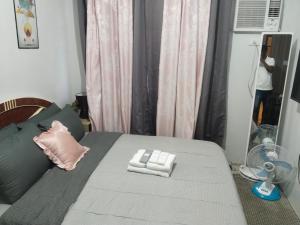 ein Schlafzimmer mit einem Bett und einem Ventilator in der Unterkunft Nice condotel in Manila