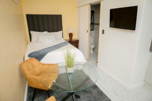 a bedroom with a bed and a glass table at BOSTON HOUSE in Cape Town