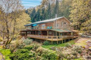 a large wooden house in the middle of a forest at Hummingbird B&B in Gabriola