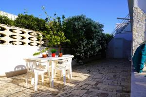 a white table and chairs on a patio at Casetta Dolce Mare - FELICITA' a DUE PASSI dal MARE in Villanova di Ostuni +44 photos
