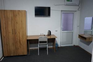 a desk in a room with a chair next to a door at Ilhombek Guest House Hotel in Tashkent