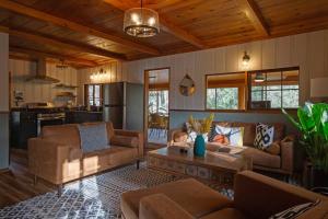 a living room with couches and a table at Dancing Pines Cabin in Prescott