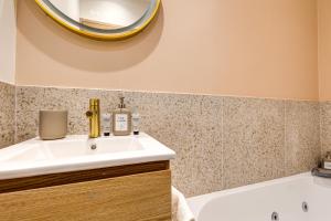 een badkamer met een wastafel, een bad en een spiegel bij Lavie Maison Hot Tub Seaside Studio in Nice