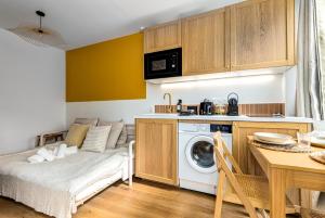 een kamer met een bed en een keuken met een wasmachine bij Lavie Maison Hot Tub Seaside Studio in Nice