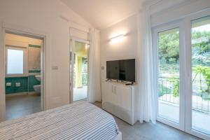 a bedroom with a bed and a tv and a balcony at Costabella Rooms in Deiva Marina