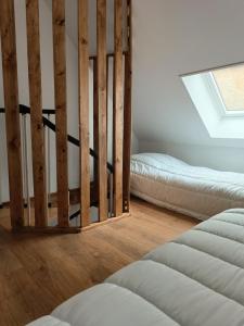 a room with two beds and a window at la parenthèse in Sainte-Mère-Église