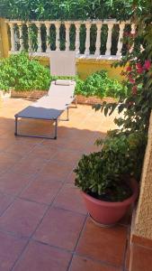 eine weiße Bank auf einer Terrasse neben einer Pflanze in der Unterkunft Adosado/casa con terraza y buhardilla. Playa El Perelló in El Perelló + 76 Fotos