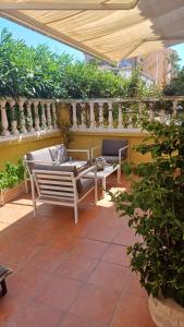 eine Terrasse mit zwei Stühlen und einem Tisch in der Unterkunft Adosado/casa con terraza y buhardilla. Playa El Perelló in El Perelló