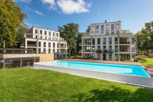 a large swimming pool in front of two buildings at Parkvillen Binz by Rujana in Binz