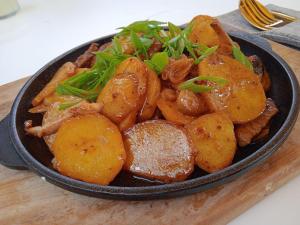 a black bowl of food on a wooden table at Hоuse Baatyr78 in Barskoon