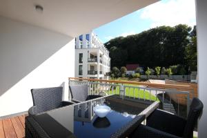 a balcony with chairs and a table with a bowl on it at Parkvillen Binz by Rujana in Binz