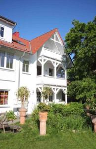 a large white house with a red roof at Studio Sonnenstrahl by Rujana in Binz