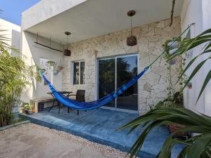 a hammock on the back of a house at Casa Foto Estudios in El Cuyo
