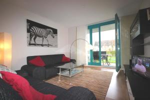 ein Wohnzimmer mit einem Sofa und einem Zebrabild an der Wand in der Unterkunft Haus Rabe by Rujana in Binz