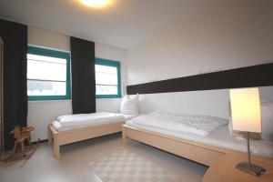 twee bedden in een kamer met twee ramen bij Haus Rabe by Rujana in Binz