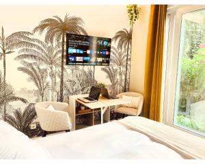 Habitación de hotel con escritorio y ordenador portátil. en Chambre Cosy chez l habitant avec salle de bain et jardin privé, en París