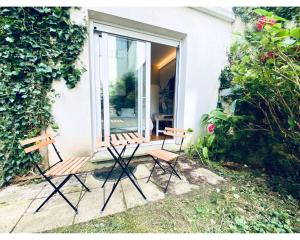 Dos bancos sentados frente a una ventana en Chambre Cosy chez l habitant avec salle de bain et jardin privé, en París