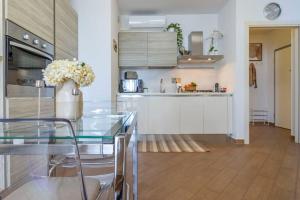 una cocina con una mesa de cristal con un jarrón de flores en Pisa AirPort-Train Station AC Free Parking, en Pisa