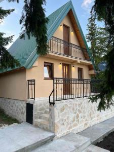 a house with a green roof and a balcony at Žabljak- FamilyOasis in Žabljak