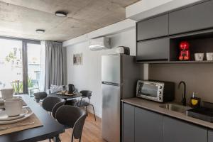 a kitchen with a refrigerator and a table with chairs at Baliñas Boutique in Montevideo