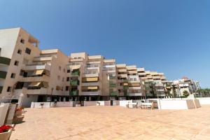 a large apartment building with a patio in front of it at RentitSpain Moderno Apartamento Calaverde Frente al Mar in Salobreña