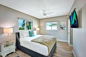 Un dormitorio con una cama y un televisor. en NEW Waterfront Tropic Oasis - Heated Pool, Canal, Dock, Air Hockey, en Boynton Beach