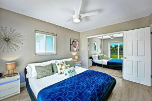 Un dormitorio con una cama grande y un espejo. en NEW Waterfront Tropic Oasis - Heated Pool, Canal, Dock, Air Hockey, en Boynton Beach 37 fotos más