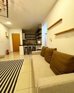 a living room with a couch and a kitchen at The Borneo Suite, 5 mins to Airport, 6-10 Guests , 2 FREE CAR PARKS in Kota Kinabalu +23 photos