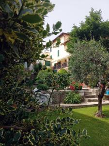 a garden with a house in the background at Giardino Fiorito in Toscolano Maderno