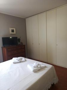 a bedroom with white cabinets and two towels on a bed at Giardino Fiorito in Toscolano Maderno +18 photos
