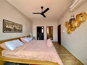 a bedroom with a large bed with a ceiling fan at Modern 2-bedroom townhouse with rooftop terrace in Kampot