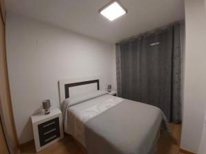 a small bedroom with a bed and a window at Apartamento El Ancla in Almería
