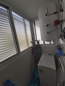 a small bathroom with a toilet and two windows at Apartamento El Ancla in Almería +20 photos