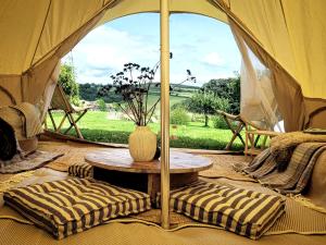 a tent with a table and a vase on it at Tylda Tents at Tregonetha Lake - 5m Luxury Bell Tent "Moorhen" in Saint Columb Major