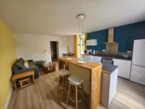 a kitchen and a living room with a counter and a kitchen and a kitchen at Maison charentaise au Cœur des Vignobles in Mérignac