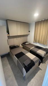 ドラゲにあるHoliday Sea Home 2023のベッドルーム1室(ベッド2台付)、窓(カーテン付)