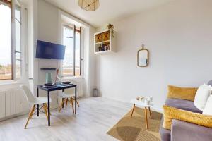 ein Schlafzimmer mit einem Bett und einem Schreibtisch in einem Zimmer in der Unterkunft Le Cocon dans les Nuages in Villeurbanne